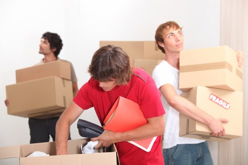 Moving professionals carrying furniture through a Highbury property